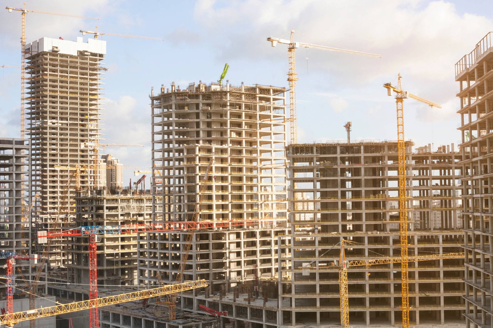 Canteiro de obras com edifícios residenciais em fase de estrutura e gruas